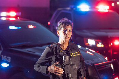 police woman in front of patrol car